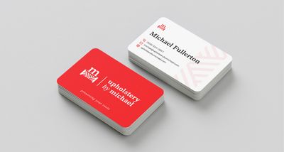 Two stacks of Upholstery By Michael business cards showing front and back