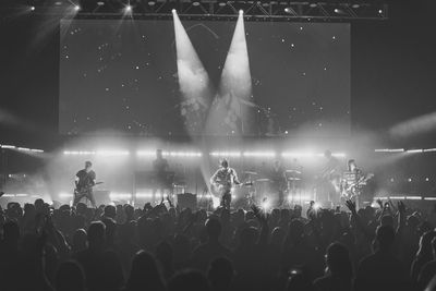 Rock band performing live on stage in front of crowd